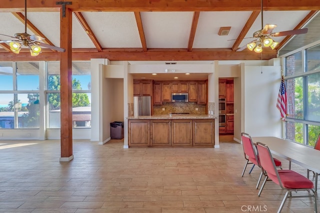 kitchen with stainless steel appliances, light stone countertops, ceiling fan, and decorative backsplash