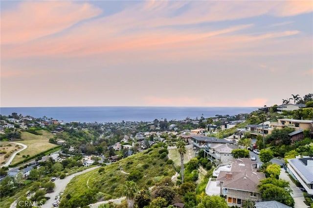 aerial view at dusk featuring a water view