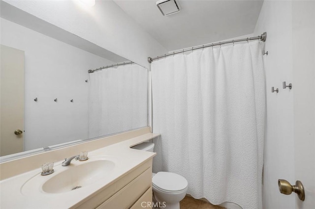 bathroom featuring vanity, toilet, and curtained shower