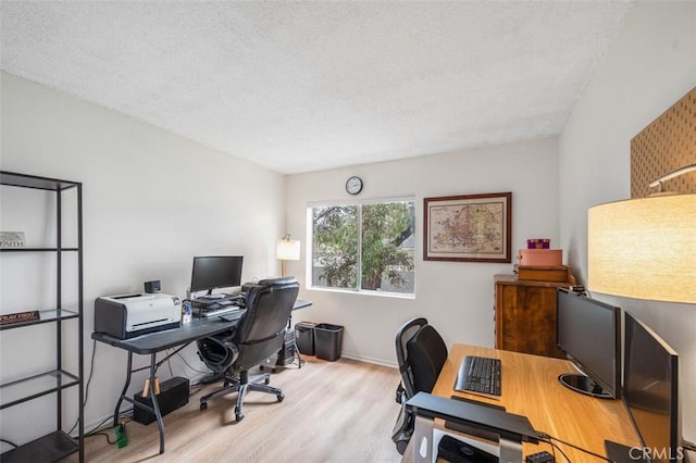 office with a textured ceiling and light wood-type flooring