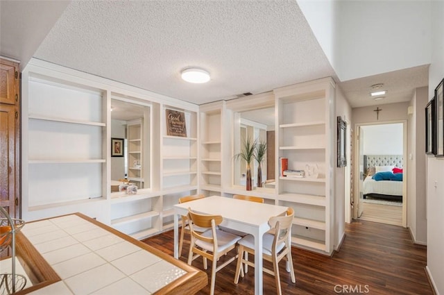 dining area featuring dark hardwood / wood-style floors and a textured ceiling