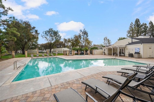 view of pool with central AC unit and a patio