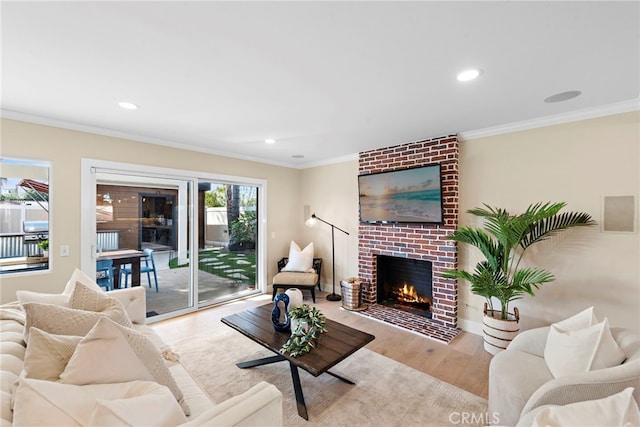 living room featuring a fireplace, ornamental molding, and light wood-type flooring