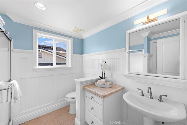 bathroom featuring sink, crown molding, tile patterned floors, and toilet