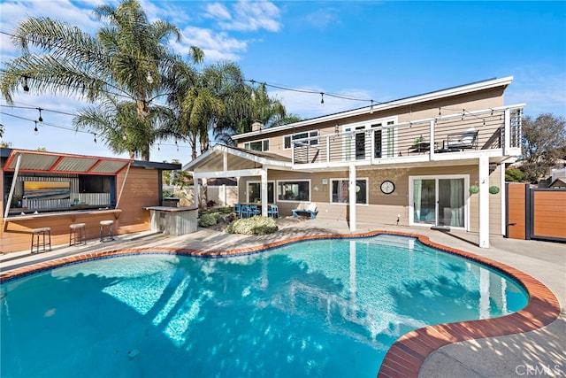 view of swimming pool with a patio area and a bar