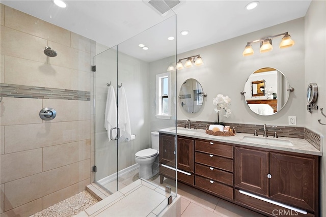 bathroom with tile patterned floors, toilet, a shower with door, and vanity