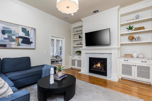 living room featuring ornamental molding, wood-type flooring, and built in features