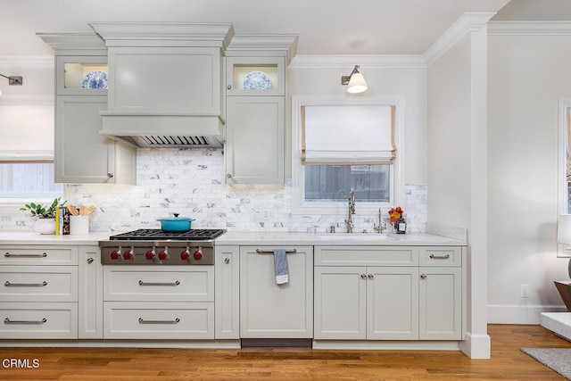 kitchen with light hardwood / wood-style flooring, sink, white cabinetry, crown molding, and stainless steel gas cooktop