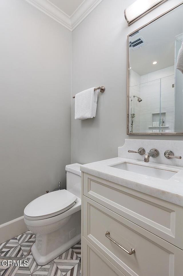 bathroom with crown molding, vanity, toilet, and a shower with door