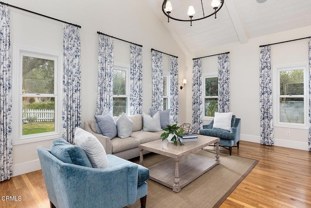 living room with a wealth of natural light, wood-type flooring, and lofted ceiling with beams