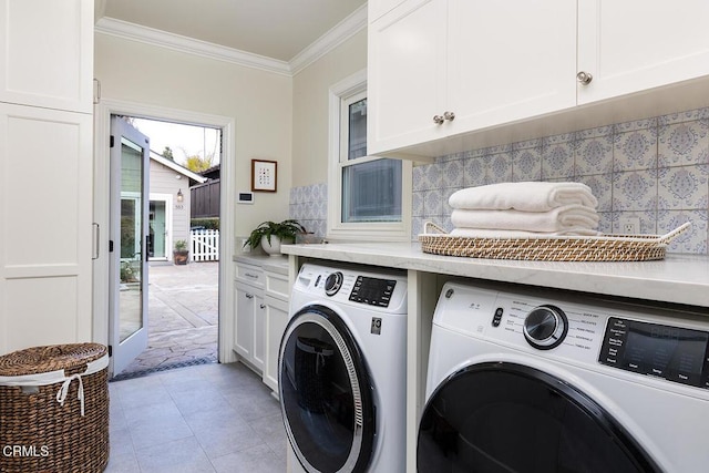 clothes washing area with washer and dryer, cabinets, ornamental molding, and light tile patterned floors