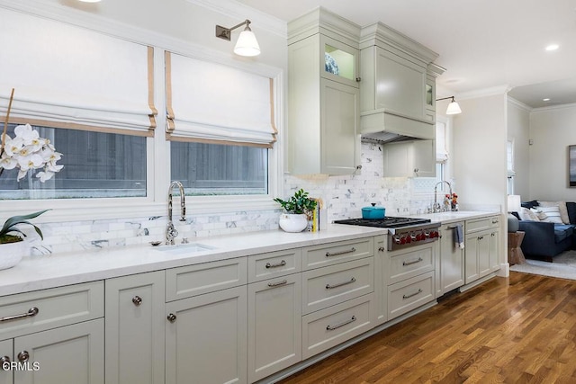 kitchen with stainless steel gas cooktop, pendant lighting, backsplash, ornamental molding, and sink