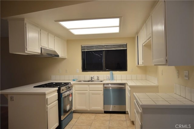 kitchen with sink, white cabinetry, light tile patterned floors, appliances with stainless steel finishes, and kitchen peninsula