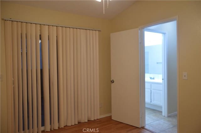 empty room featuring vaulted ceiling and light hardwood / wood-style flooring