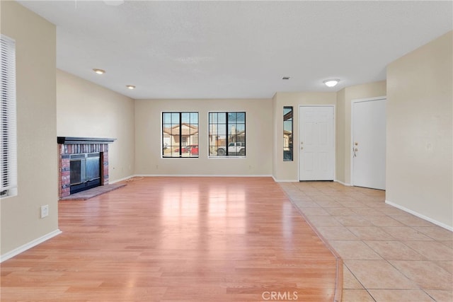 unfurnished living room featuring light wood-style floors, a fireplace, and a textured ceiling