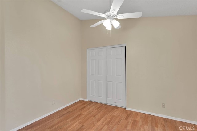 unfurnished bedroom with light wood-style floors, a closet, ceiling fan, and baseboards