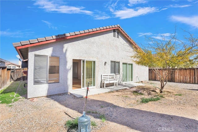 rear view of property with a patio, a fenced backyard, and stucco siding