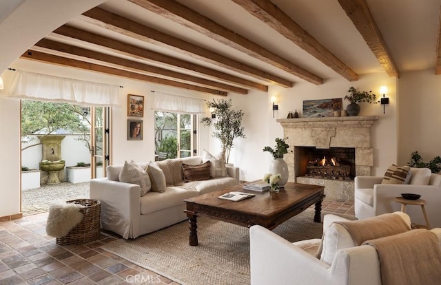 living room with beam ceiling and a high end fireplace