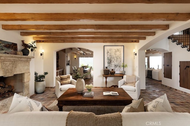 living room featuring beamed ceiling and a fireplace