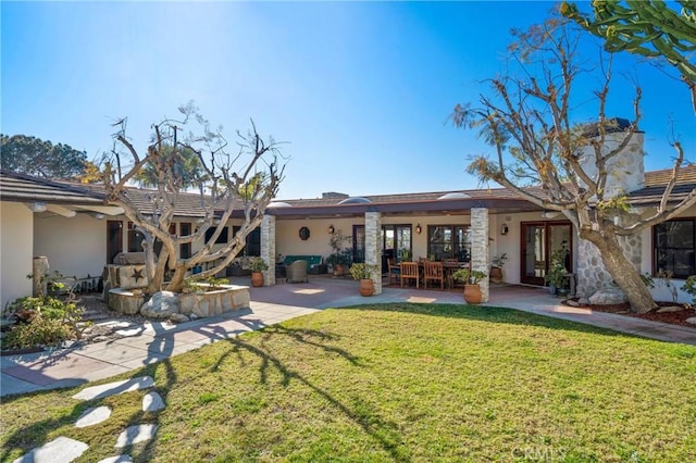 back of property with a patio and a yard