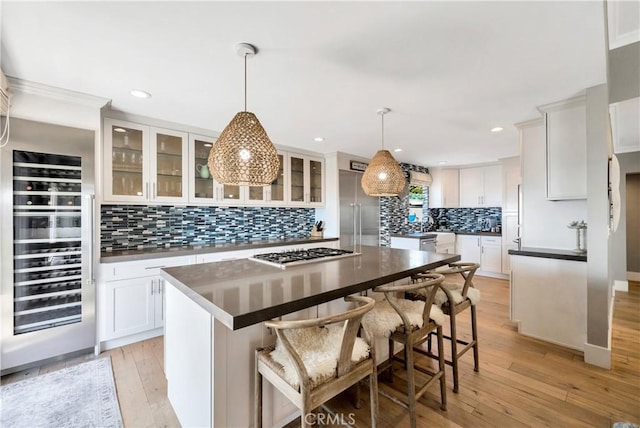 920 Quivera St, Laguna Beach, CA 92651 - kitchen featuring wine cooler, backsplash, appliances with stainless steel finishes, white cabinets, and glass insert cabinets