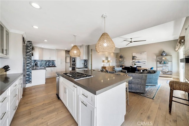 920 Quivera St, Laguna Beach, CA 92651 - kitchen with stainless steel appliances, tasteful backsplash, a kitchen island, light wood finished floors, and a ceiling fan