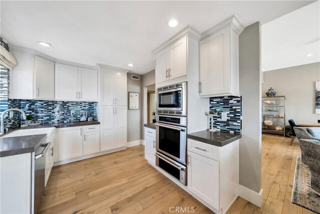 920 Quivera St, Laguna Beach, CA 92651 - kitchen with stainless steel appliances, a warming drawer, dark countertops, decorative backsplash, and recessed lighting