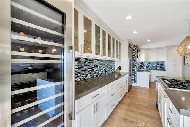 920 Quivera St, Laguna Beach, CA 92651 - kitchen featuring beverage cooler, stainless steel gas cooktop, dark countertops, tasteful backsplash, and light wood-type flooring