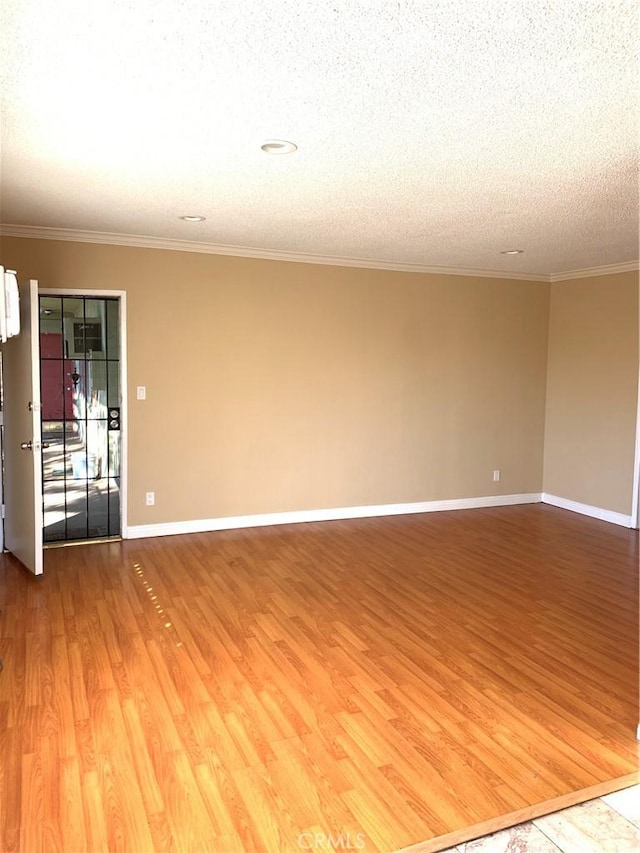 unfurnished room featuring hardwood / wood-style floors, crown molding, and a textured ceiling