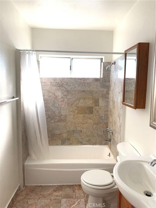 full bathroom with shower / tub combo with curtain, vanity, and toilet