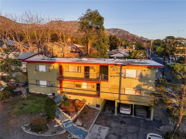 rear view of house featuring a balcony and a mountain view