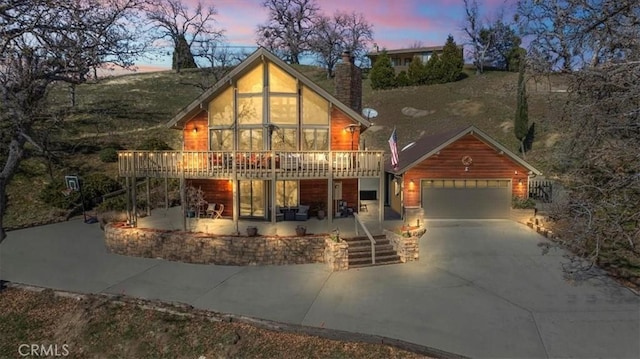 view of front facade featuring a garage, a patio area, and a deck