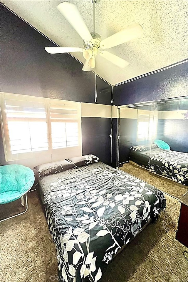 carpeted bedroom featuring ceiling fan and a textured ceiling