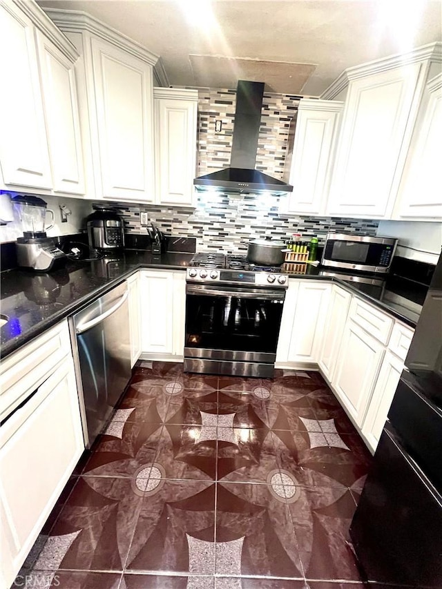 kitchen featuring dark stone countertops, decorative backsplash, wall chimney exhaust hood, and appliances with stainless steel finishes