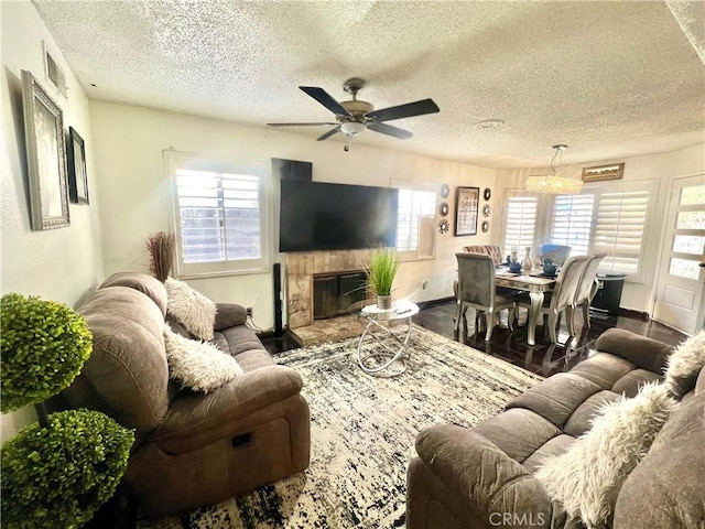 living room with hardwood / wood-style flooring, a textured ceiling, and ceiling fan