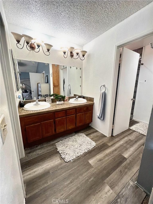 bathroom featuring vanity, hardwood / wood-style floors, and a textured ceiling