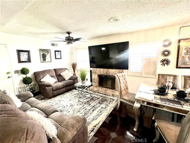 living room with a textured ceiling and ceiling fan