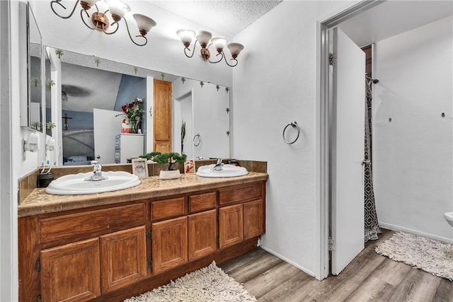 bathroom with hardwood / wood-style flooring, vanity, and a textured ceiling