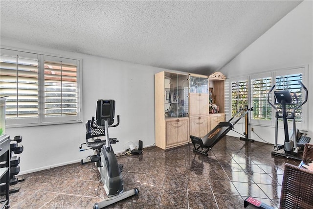 workout area featuring a textured ceiling and vaulted ceiling