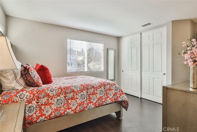 bedroom with a closet and dark wood-type flooring