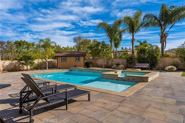 view of swimming pool featuring an in ground hot tub, a patio, and a storage shed