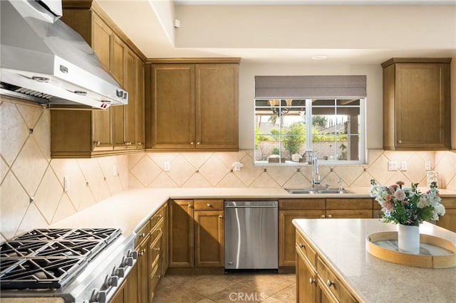 kitchen featuring ventilation hood, sink, stovetop, backsplash, and stainless steel dishwasher