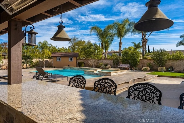 view of swimming pool featuring an in ground hot tub, a storage shed, and a patio