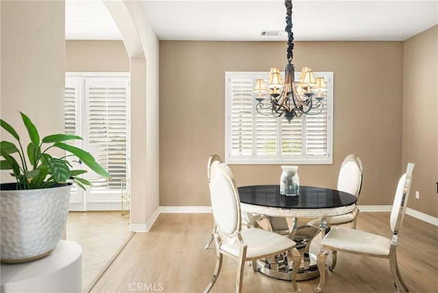 dining area with a notable chandelier and light wood-type flooring