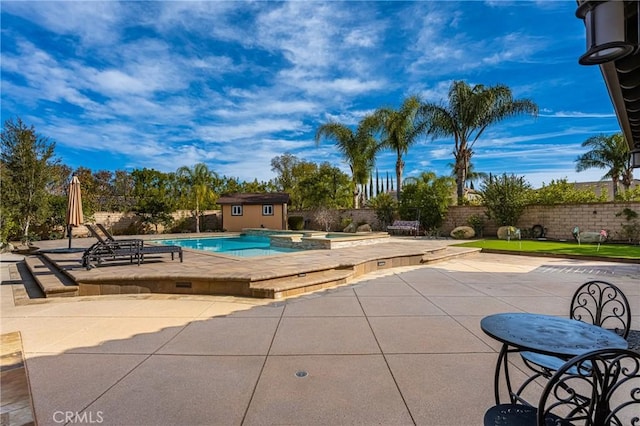 view of pool with an in ground hot tub, a storage unit, and a patio area