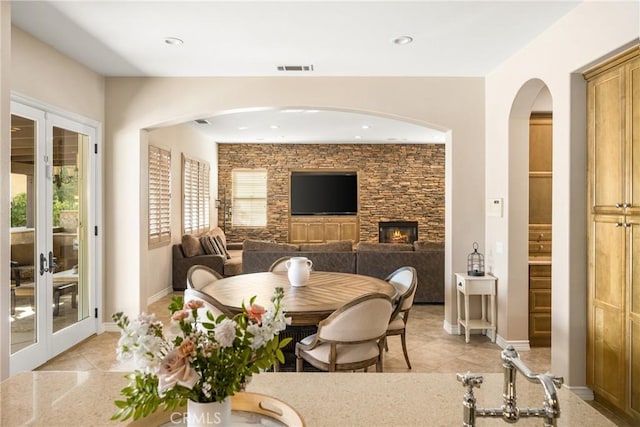 dining space featuring light tile patterned flooring and a fireplace