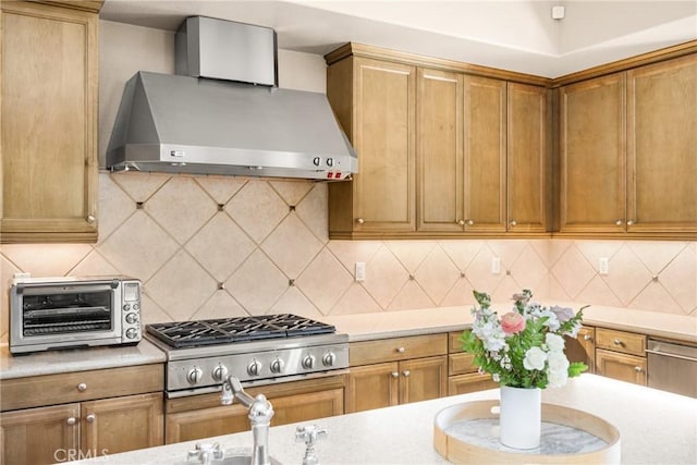 kitchen with wall chimney range hood, decorative backsplash, and stainless steel gas stovetop