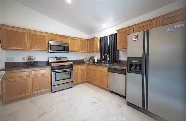 kitchen featuring stainless steel appliances, lofted ceiling, sink, and dark stone countertops