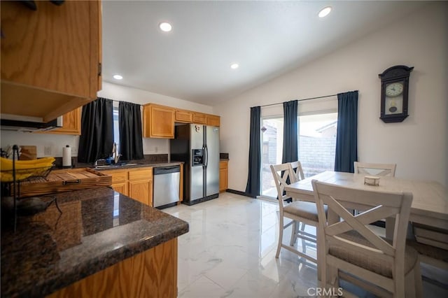 kitchen featuring dark stone countertops, sink, vaulted ceiling, and appliances with stainless steel finishes