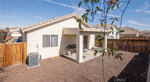 rear view of property featuring a patio and central AC